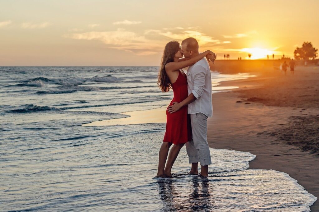 junges Paar küsst sich am Strand Verrückte Reiseziele Europa Außergewöhnliche Urlaubsaktivitäten